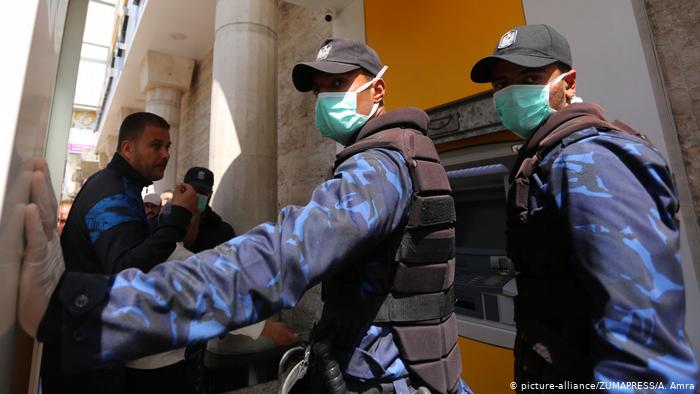 Palestinian Authority employees wait to receive their salaries from an ATM (photo: picture-alliance/ZUMAPRESS/A. Amra)