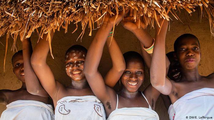 Four young Ivorian women holding a bale of hay (photo: DW/E. Lafforgue)