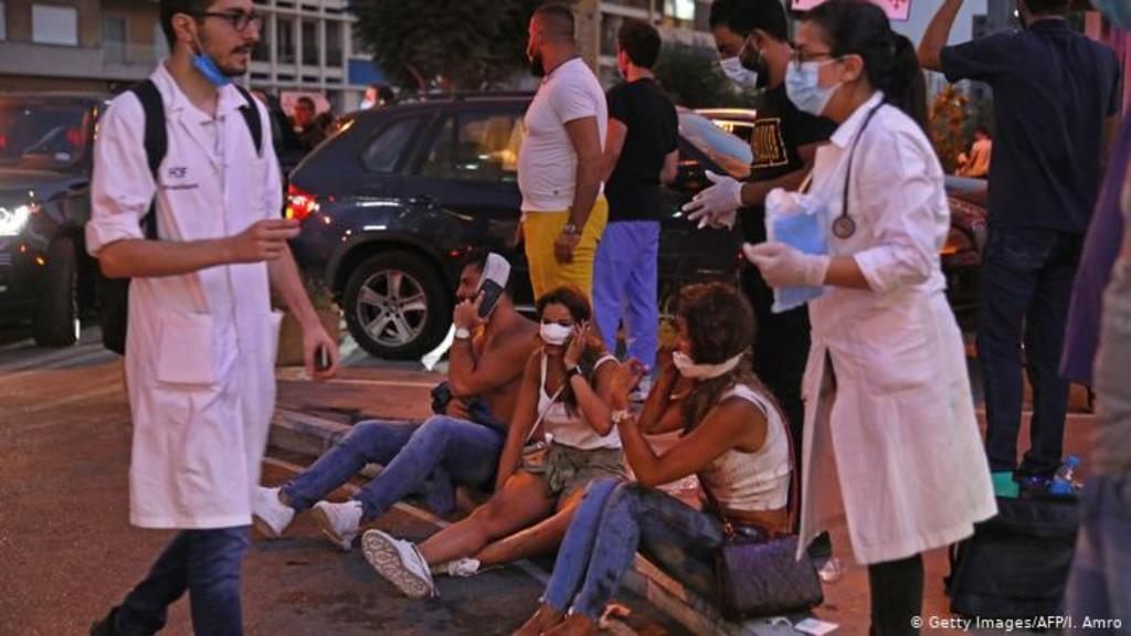 Menschen sitzen vor einem Krankenhaus auf dem Boden, medizinisches Personal geht an ihnen vorbei (Getty Images/AFP/I. Amro)