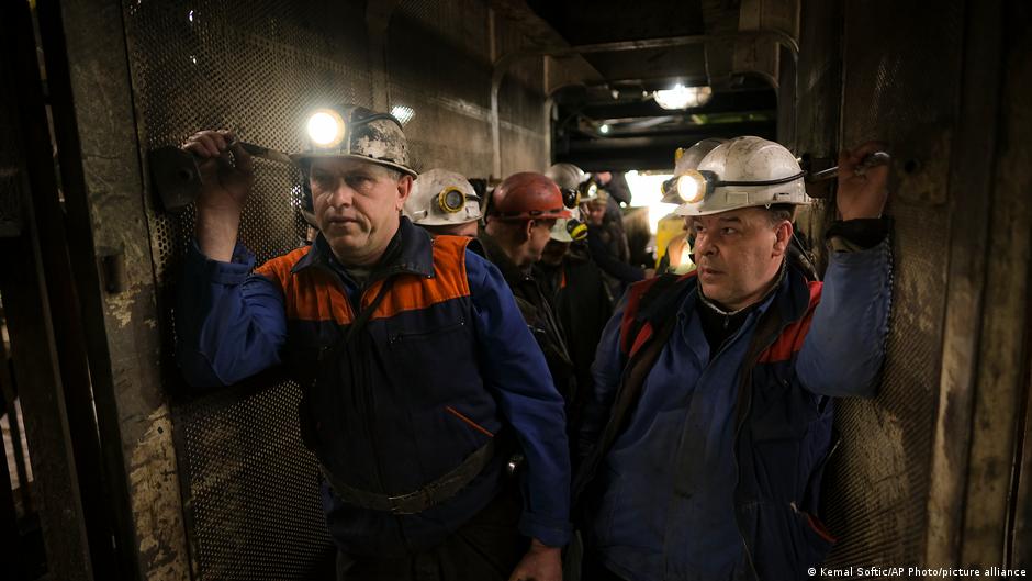 Bosnische Bergarbeiter halten Säcke mit Lebensmitteln in der Hand, als sie in einem Aufzug stehen, der sie unter Tage in einem Bergwerk in Zenica, Bosnien, bringt, 29. April 2021. Foto: AP Photo/Kemal Softic