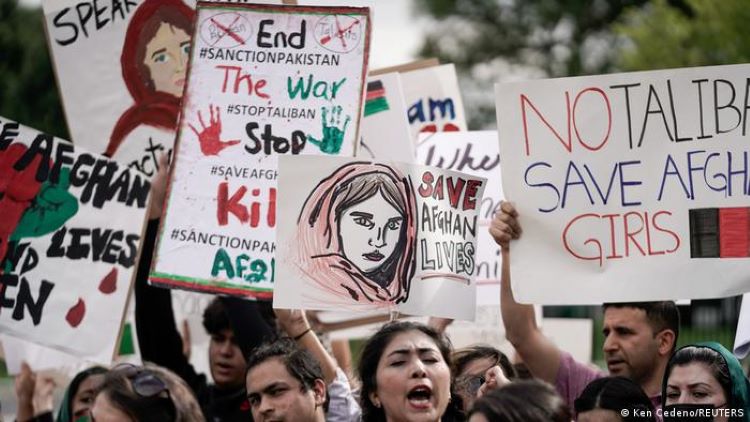 Demonstrators in Washington hold up placards calling for peace in Afghanistan (photo: Ken Cedeno/Reuters)