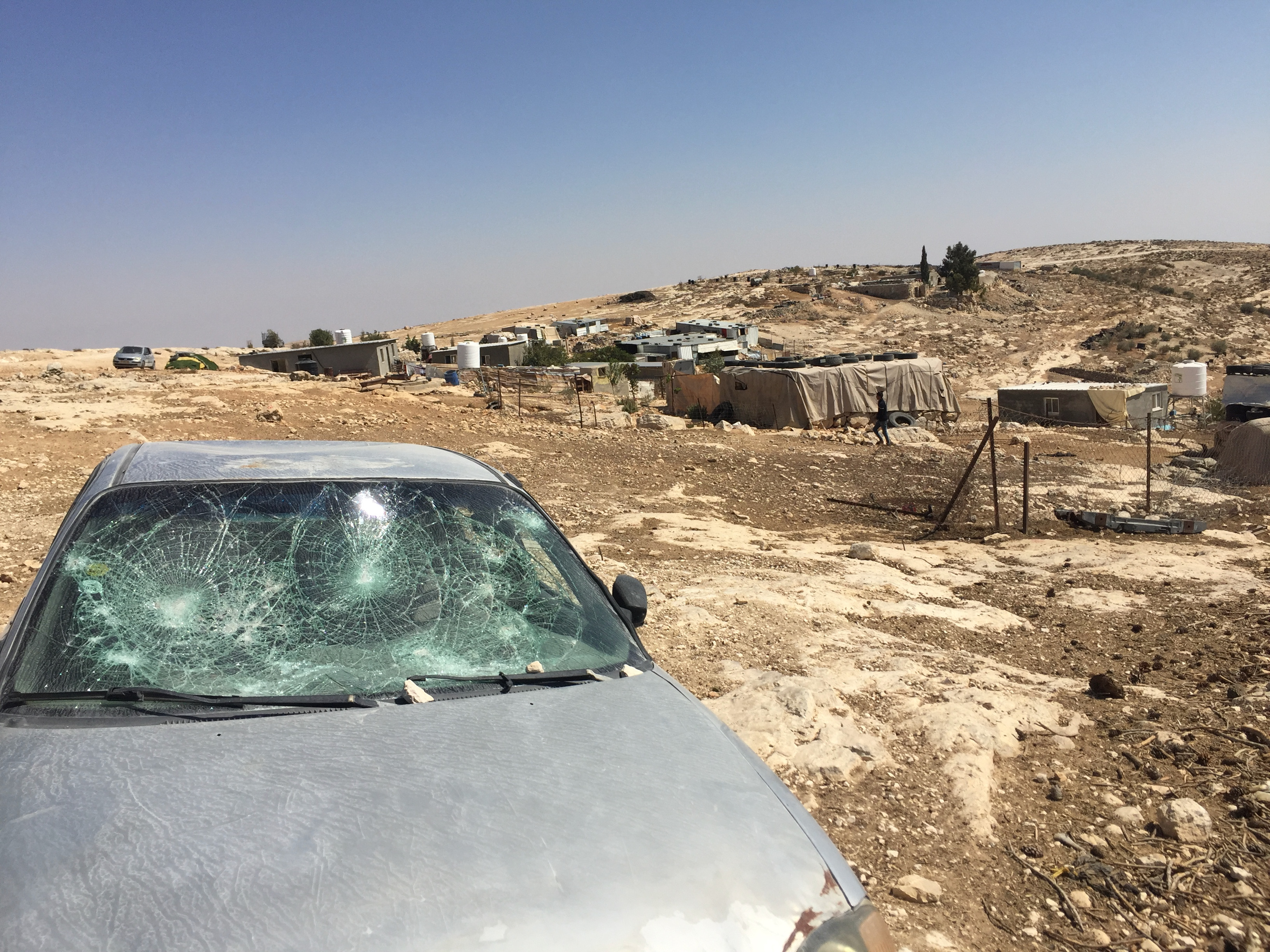 One of the destroyed car windows, in the background the village of Mufkara.