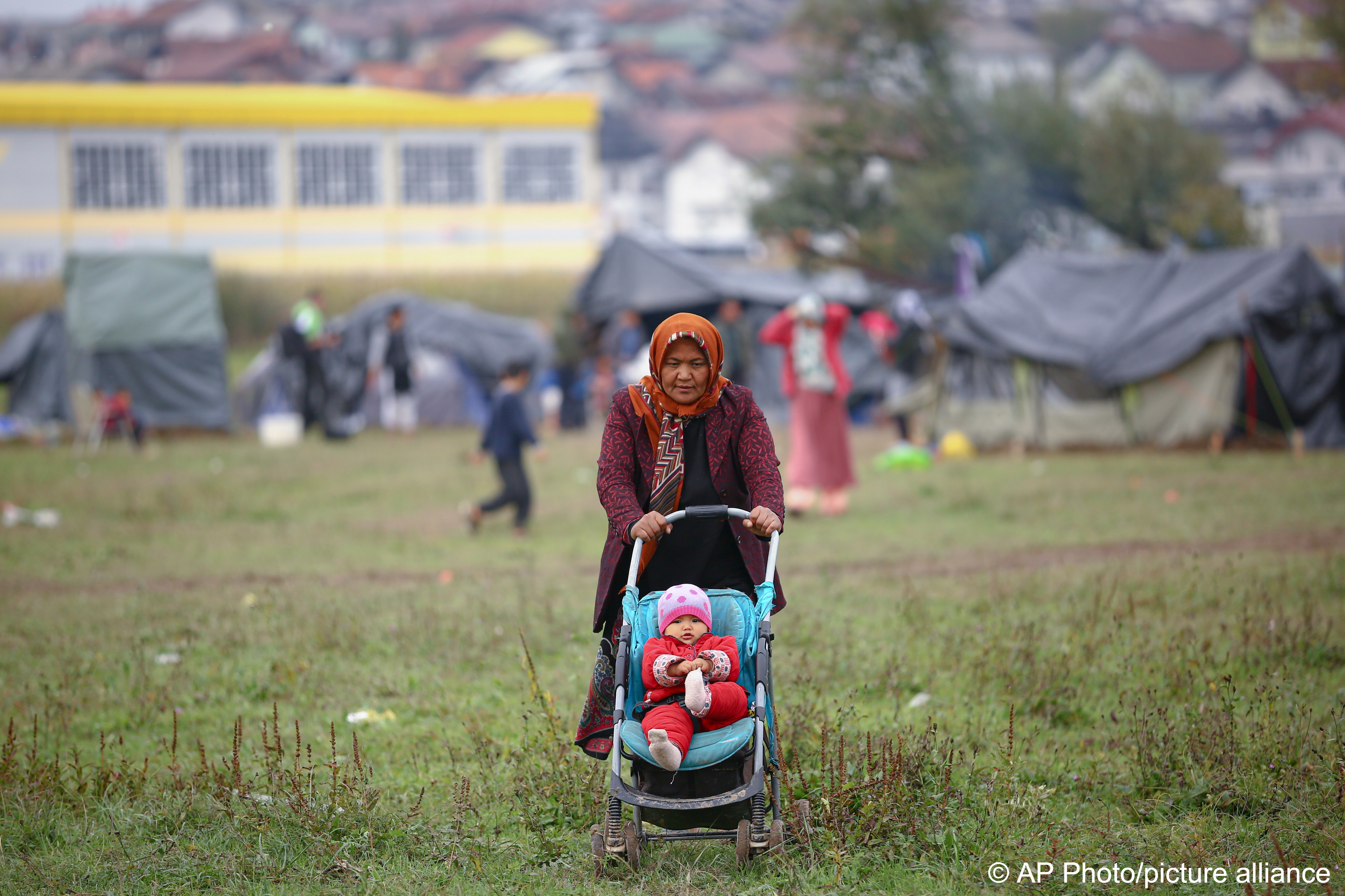 Eine Migrantin schiebt einen Kinderwagen in einem Behelfslager für Migranten, die hauptsächlich aus Afghanistan stammen, in Velika Kladusa, Bosnien, am 12. Oktober 2021; Foto: AP Photo