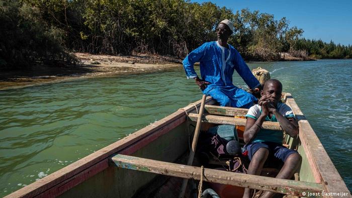 A man and a boy in a wooden boat off the coast of Saint-Louis, Senegal