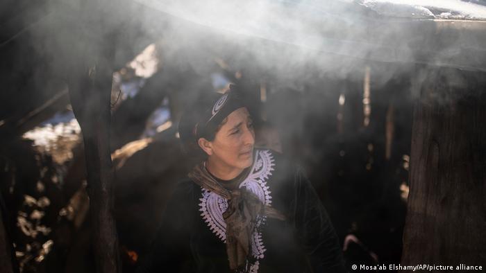 ثلوج حاصرت سكان قرية "تيمحضيت" المغربية 03 Frau in Timahdite steht an einem Ofen und backt Brot AP Photo Mosa'ab Elshamy