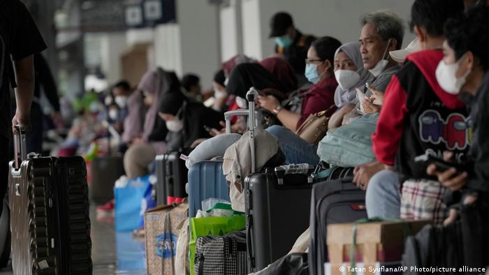 Luggage and dozens of people wearing masks to prevent the spread of the coronavirus