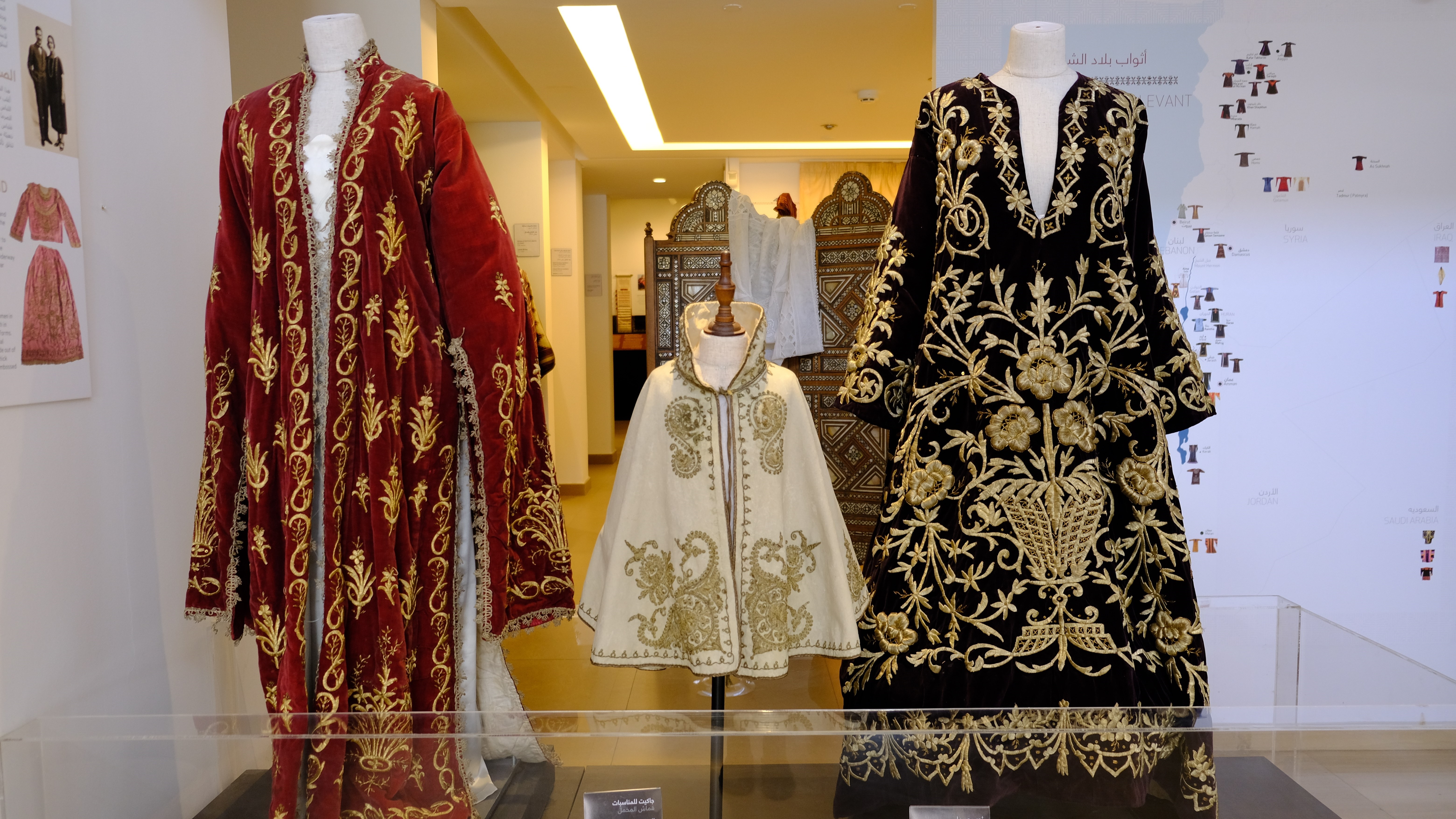 نماذج من أزياء فلسطين المعروضة في متحف "طِراز" في الأردن.  Luxurious early 20th-century dresses embroidered with gold thread; the dress on the right is a wedding dress from Palestine from 1910, the others from the 1920s (photo: Marta Vidal)