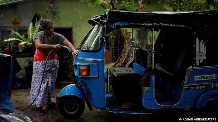 Lasanda Deepthi washes her TukTuk in the morning (photo: REUTERS/Adnan Abidi)