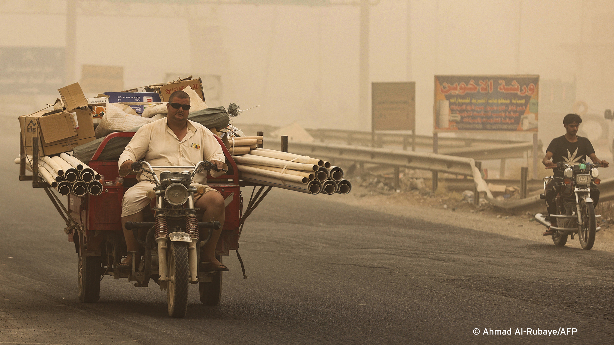 People ride during a sandstorm in the town of Khalis in Iraq's Diyala province on 3 July: the country of 41 million, despite the mighty Tigris and Euphrates rivers, is suffering from water shortages and declining rainfall.