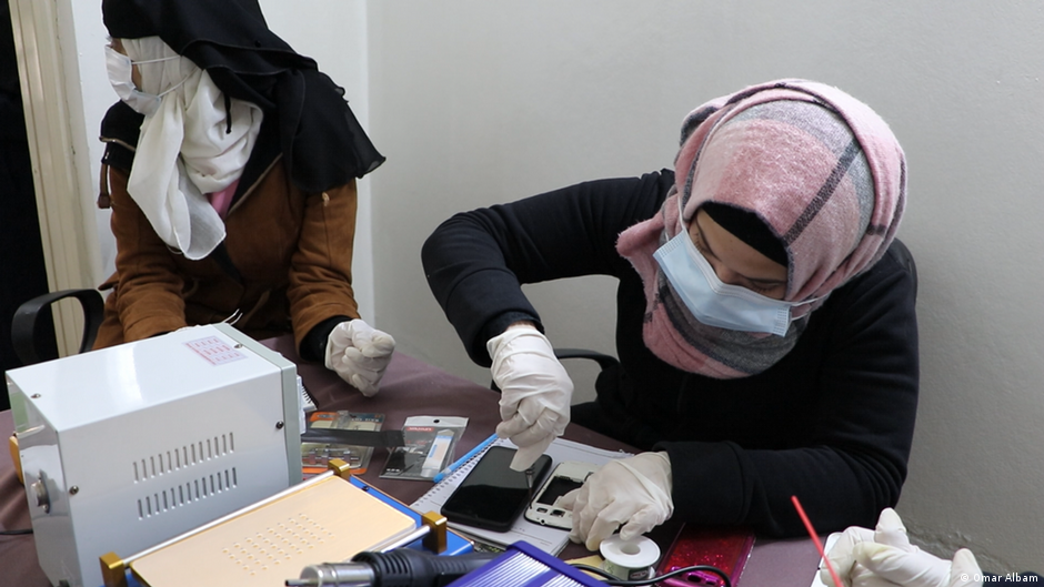 A woman in Syria repairs a mobile phone (photo: Omar Albam)