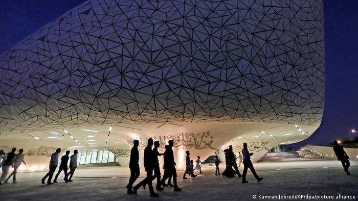 Students walk in front of the curved School of Islamic Studies building in Doha