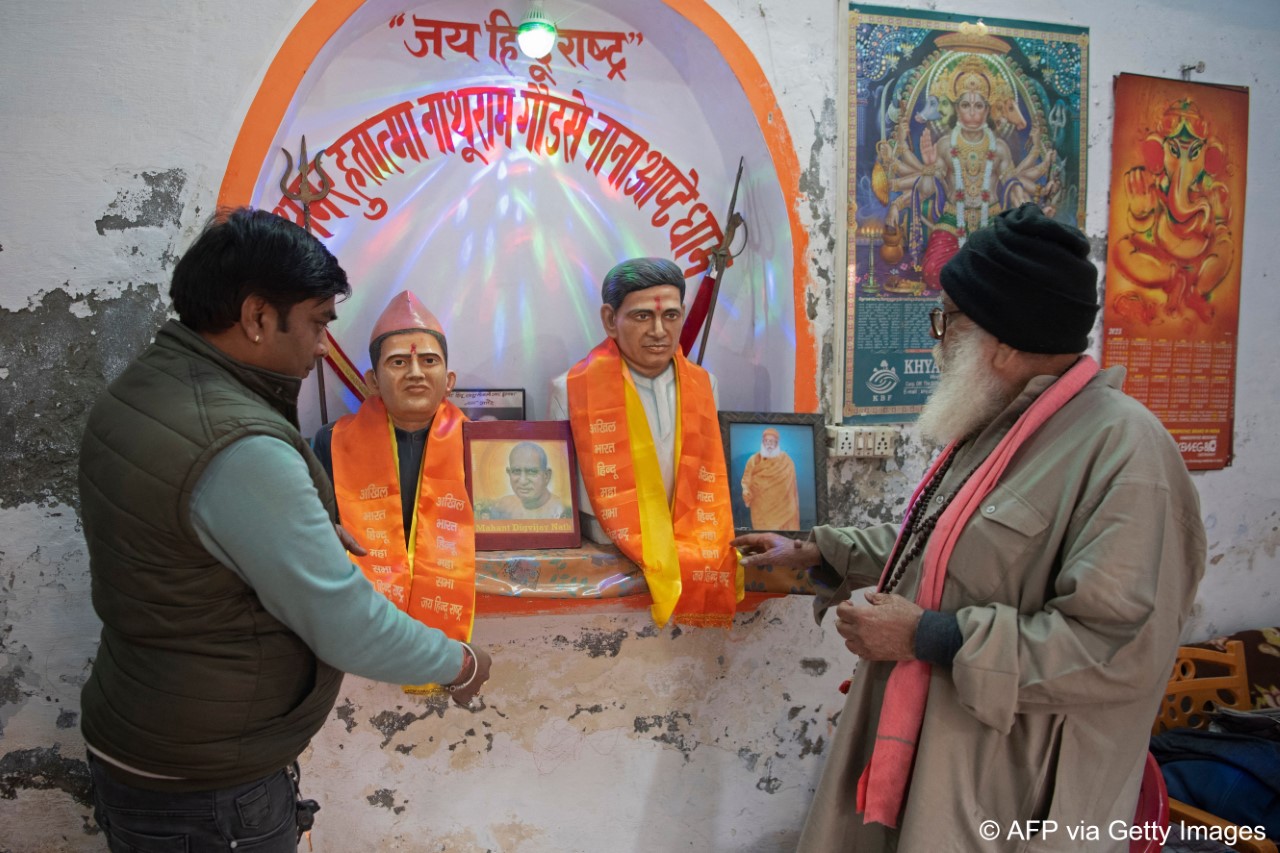 Hindu fundamentalist and priest Ashok Sharma (R) and an Hindu Mahasabha member perfrom a daily ritual over the statues of Mahatma Gandhi’s assassin Nathuram Godse (L) and his chief accomplice, Narayan Apte (image: Jalees ANDRABI/AFP)