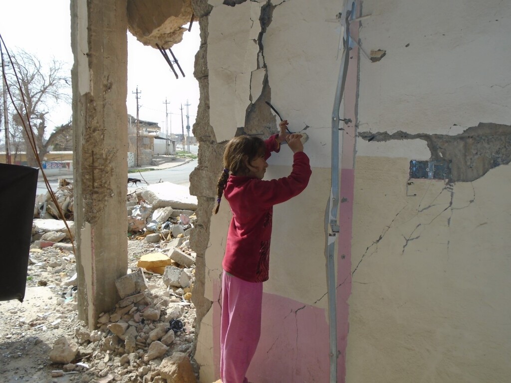 سنجار مدينة أشباح - العراق. Ein Mädchen sucht nach Nägeln und Schrauben in einer Hauswand in Sindschar; Foto: Birgit Svensson