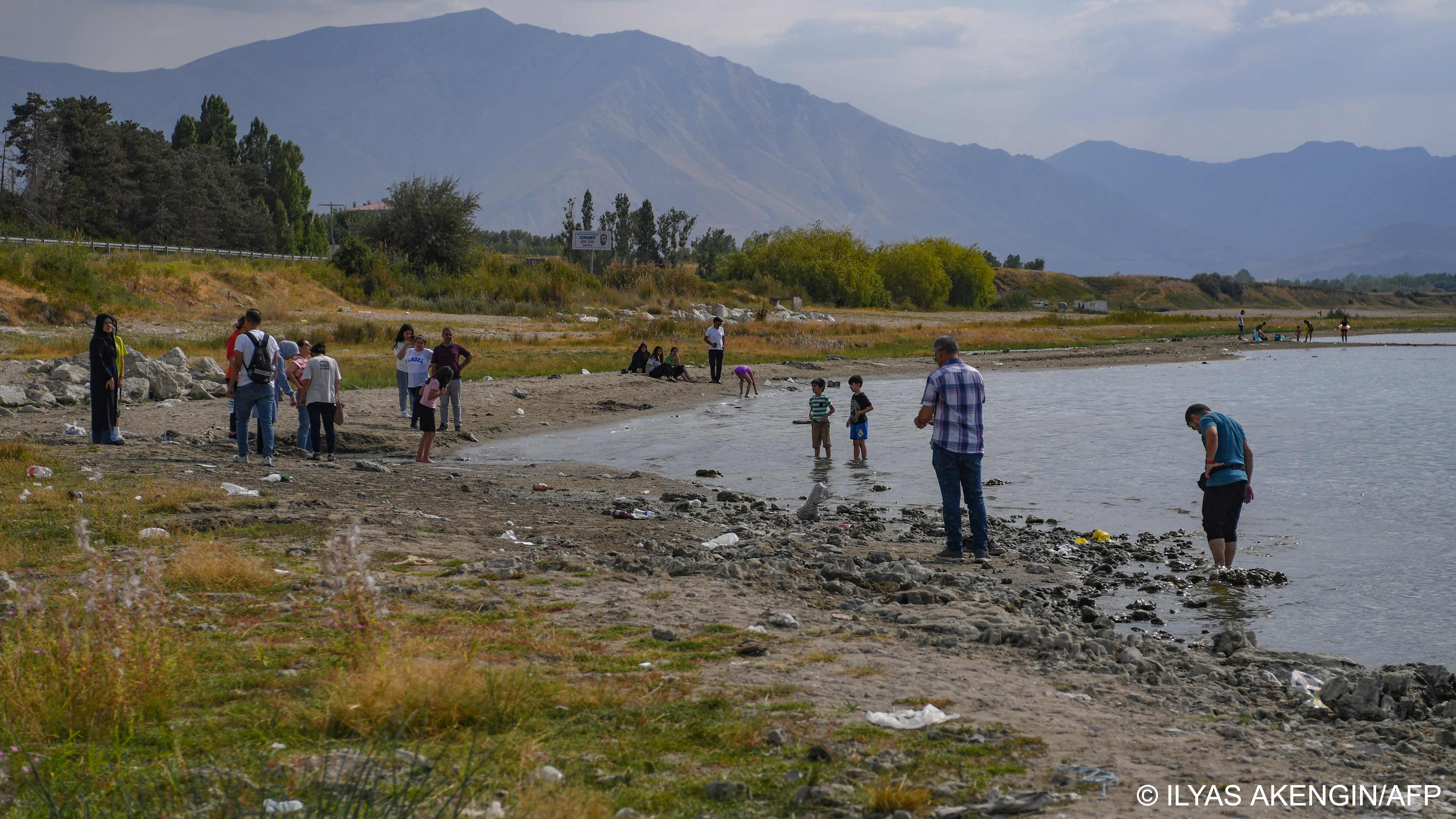 People stand next to ancient underwater rock-like structures, called microbialites, revealed as the waters of Lake Van recede (image: ILYAS AKENGIN/AFP)