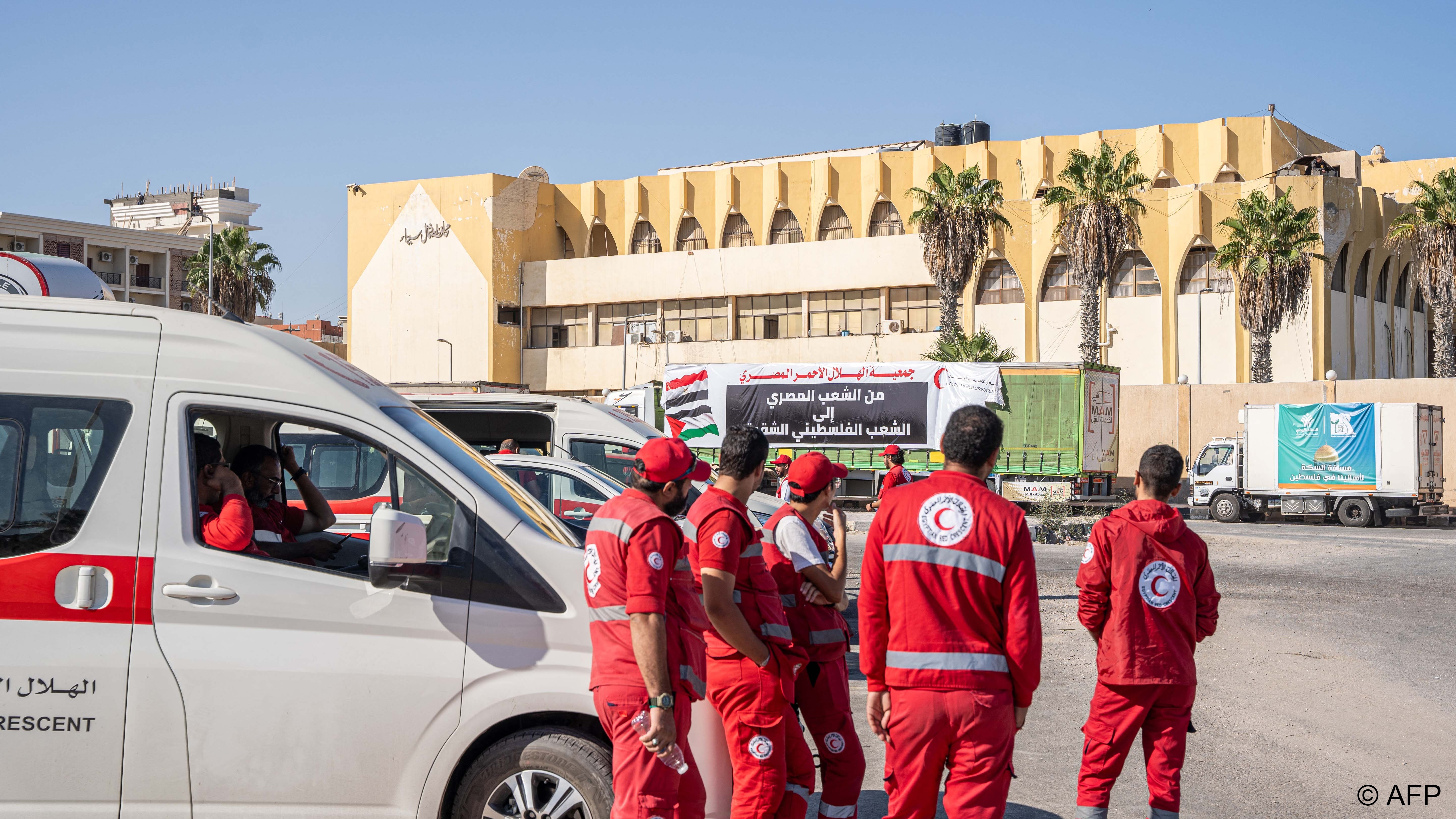 Sanitäter und LKWs mit Hilfsgütern für Gaza einer ägyptischen NGO warten an der Grenze Ägyptens zu Gaza (Foto: Ali Moustafa / AFP)