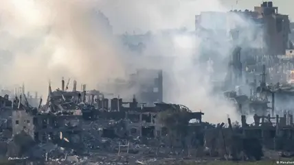 Smoke and dust rises above a ruined urban landscape