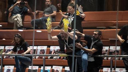 Israeli protesters demand the return of Hamas-held hostages, smearing yellow paint on the windows of Israel's parliament in early April 