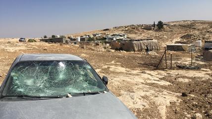 One of the destroyed car windows, in the background the village of Mufkara.