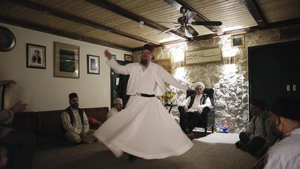 صوفيون خلال جلسة الدعاء والذكر في كونستانس (كونستانتس) في ألمانيا. During "dhikr", Sufis try to get closer to God through musical meditation – here at the Rabbaniyya Centre on Lake Constance, Germany (photo: Julius Matuschik/islamimbild.de)