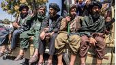 Men bearing arms sit on the back of a truck. Taliban and Taliban supporters gathered in front of the American embassy in Kabul on 15 August 2023 to celebrate the second anniversary of their takeover of the country