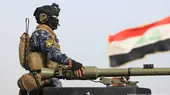 A soldier takes part in a military parade held at the police academy in Baghdad. An Iraqi flag is seen in the background