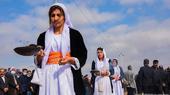 Women burn incense in a procession during a mass funeral for Yazidi victims of Islamic State (IS) in the northern Iraqi village of Kojo in Sinjar district