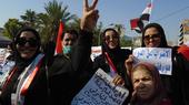 Women dressed in black carrying placards and Iraqi flags demonstrating on Tahrir Square in Baghdad, Iraq in 2019