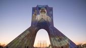 The portrait of a nurse in a protective suit is projected onto the Azadi monument in Tehran.