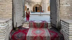 Ein Mädchen wartet an der Türschwelle zum Mausoleum von Sheikh Ahmad e-Dscham in der nordostiranischen Stadt Torbat e-Dscham
