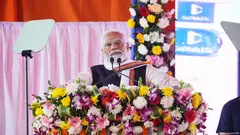 Indian Prime Minister Narendra Modi looks serious as he stands at a lectern covered in flowers