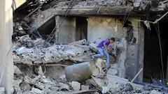 A boy inspects the damage to a building after an Israeli attack in the Lebanese village of Akbieh.