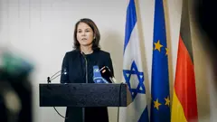 Bundesaussenministerin, aufgenommen bei einem Pressestaatement vor dem Hintergrund der israelischen, europäischen und deutschen Flaggen